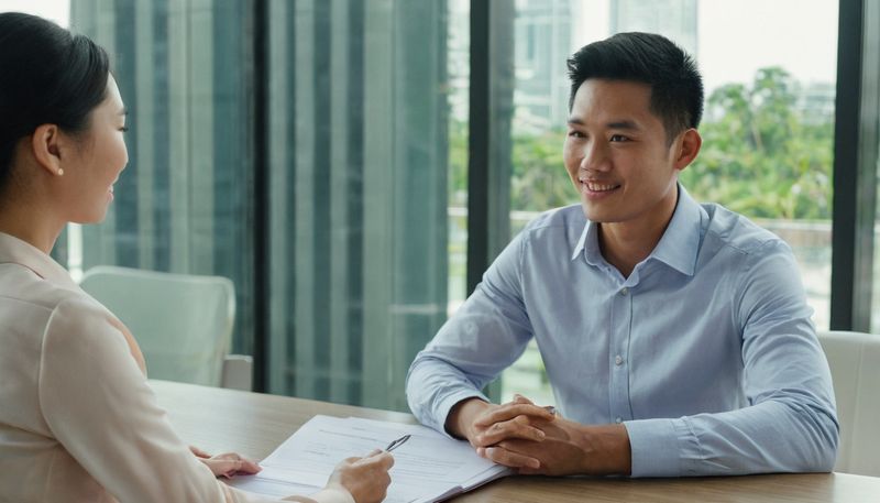 A job applicant talking with an interviewer across a desk during a job interview